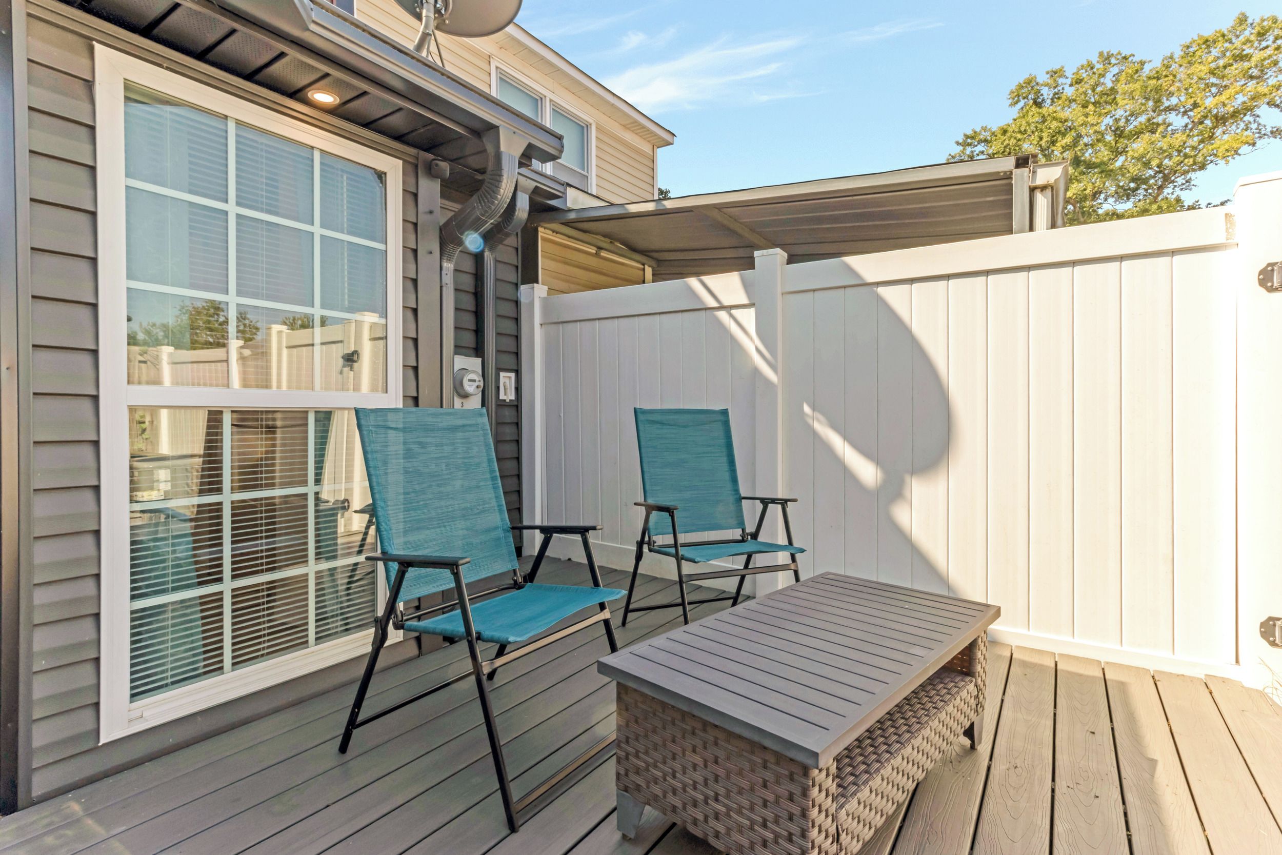 A covered patio with two chairs and a table.