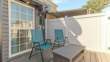 A covered patio with two chairs and a table.