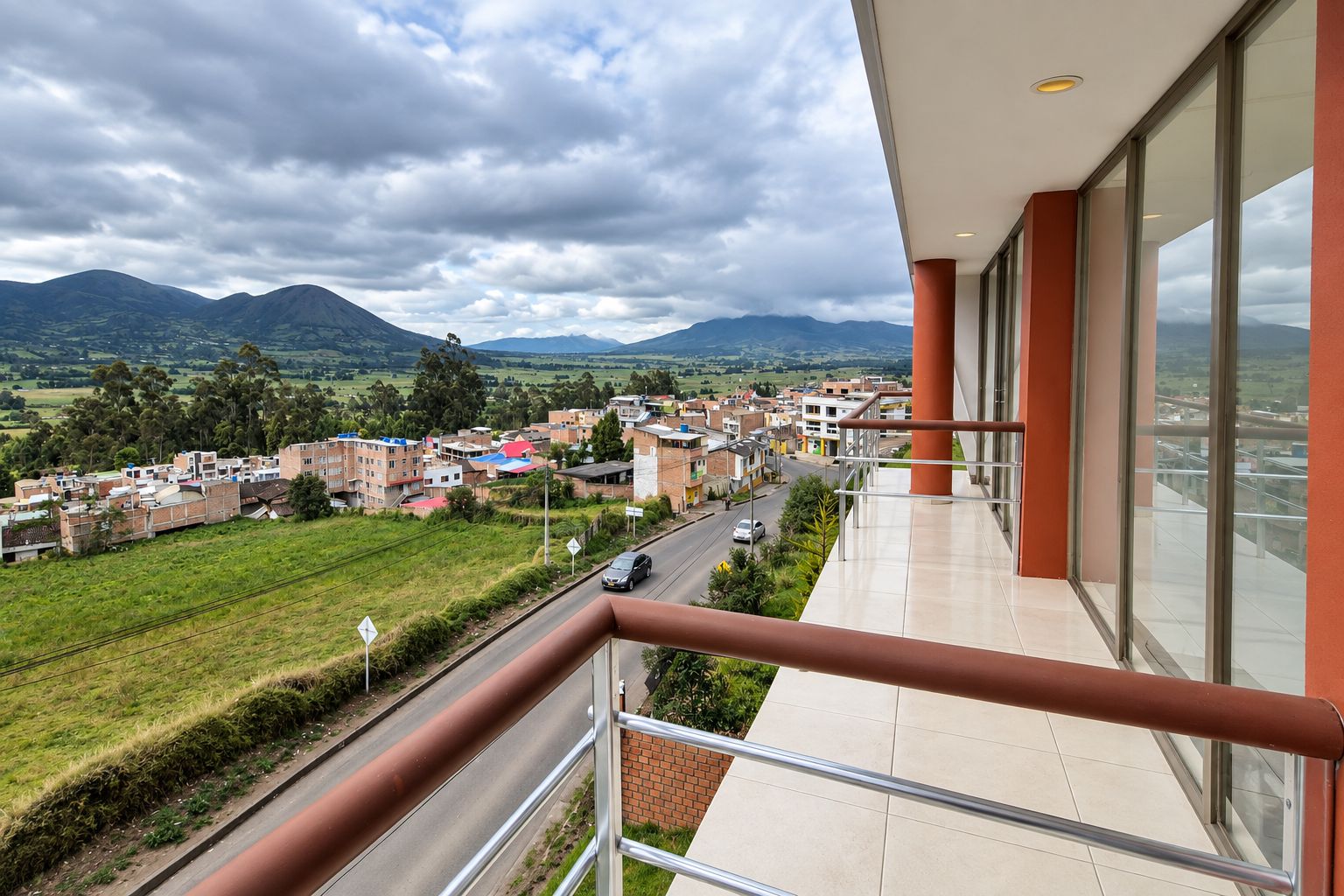 Un balcón con vistas a un pueblo y montañas.