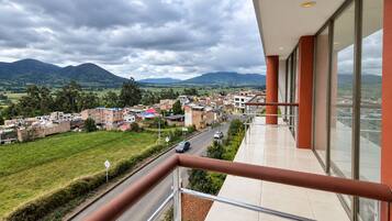 Un balcón con vistas a un pueblo y montañas.