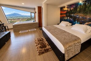 A bedroom with a large bed, a view of the outdoors, and a painting on the wall. - HOTEL NALNOA REAL (Guachucal)