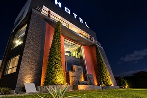 A modern hotel with a prominent 'HOTEL' sign, large windows, and a well-lit entrance. - HOTEL NALNOA REAL (Guachucal)