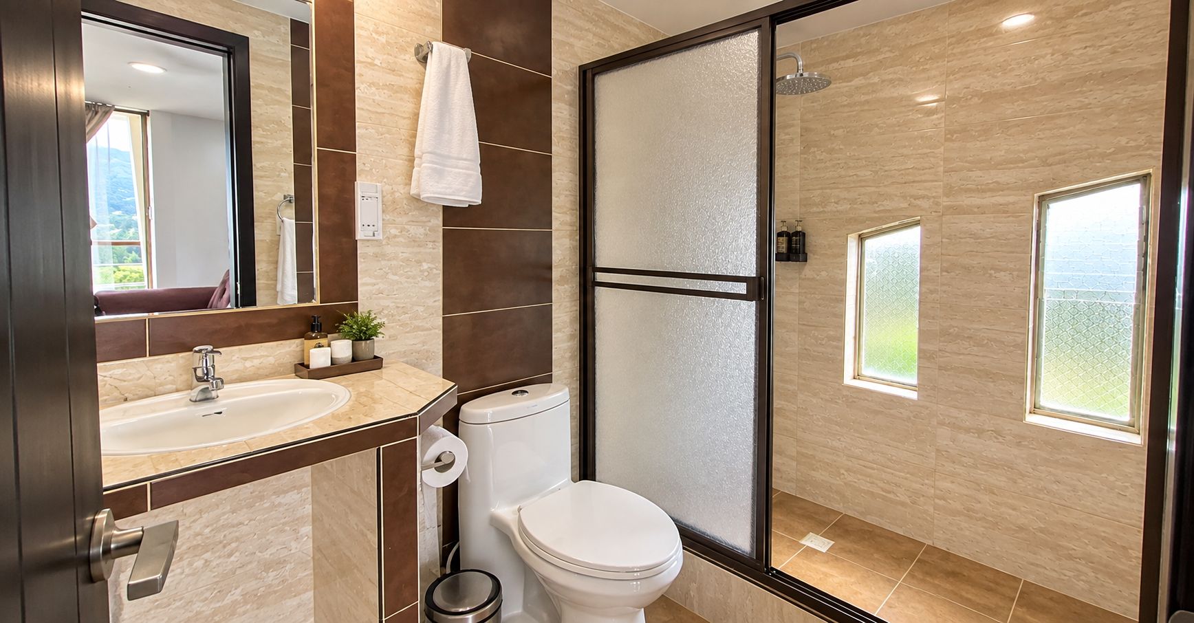 Een moderne badkamer met toilet, wastafel en douche.