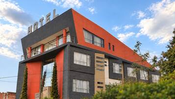 Un hotel moderno con techo plano, ventanas grandes y un llamativo letrero que dice 'HOTEL'.