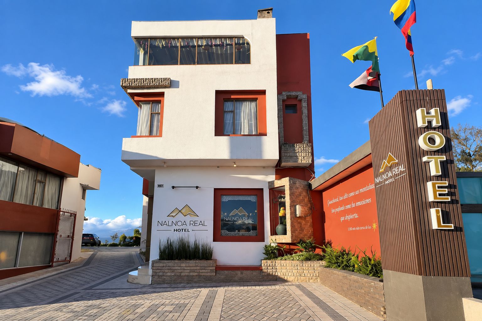 Un hôtel à deux étages doté d’une façade moderne, d’une entrée imposante et d’une enseigne indiquant le nom de l’hôtel.
