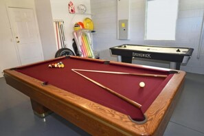 A pool table with balls and cues, a second table labeled 'BRUNSWICK,' and a tire rack with various items. - 4 bedroom accommodation in Kissimmee (Kissimmee)
