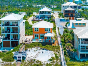 A coastal residential area with multiple two-story houses, a sandy beach, and a wooden boardwalk. - Summer Salt (Port St. Joe)