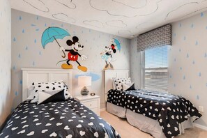 A child's bedroom with two beds, a nightstand, a lamp, and Mickey Mouse wall decals. - Poolside Paradise!

Poolside Paradise! (Davenport)