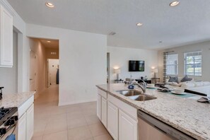 A modern kitchen with white cabinetry, granite countertops, and a built-in dishwasher. - Poolside Paradise!

Poolside Paradise! (Davenport)