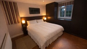 A neatly made bed with white linens, a headboard, and two bedside lamps. - 10 min walk to York Minster & Station (York)