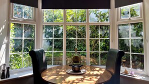 A bay window with multiple panes, a round wooden table with a globe and candle holders, and two chairs. - 10 min walk to York Minster & Station (York)