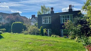 A residential property with a brick house, a well-maintained lawn, and a clear blue sky. - 10 min walk to York Minster & Station (York)