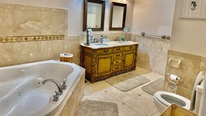 Een badkamer met een bad, een dubbele wastafel en een toilet.