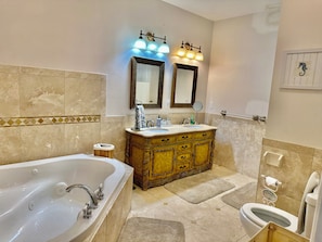 A bathroom with a bathtub, double sink vanity, and a toilet. - Perrydise Lakehouse with Pool, Hot Tub & Sunset Views (Shelby)