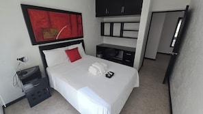 A hotel room with a bed, a desk, a chair, a red abstract painting, and a wardrobe. - La reserva suites (Santiago de Querétaro)