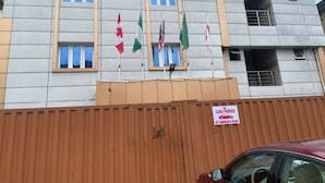 Un edificio con varias ventanas y un cartel que indica que los vehículos estacionados quedan bajo la responsabilidad del propietario.