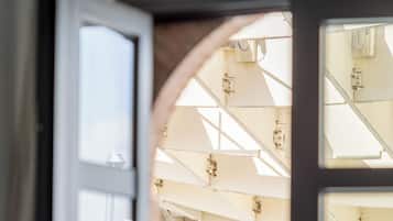 Puerta abierta que muestra el interior de una habitación, con una ventana y un techo con vigas estructurales.