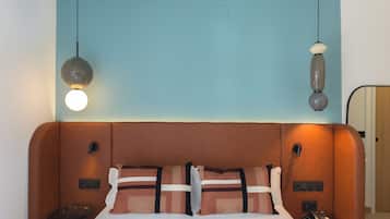 Ein Hotelzimmer mit einem großen Bett, zwei Nachttischen, einem Schminktisch, einem Spiegel und einer Deckenleuchte.