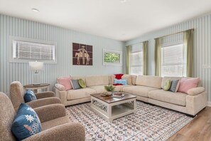 A living room with a beige sectional sofa, a coffee table, and patterned rug. - Cowboy Cottage: Sleeps 12 (Nashville)