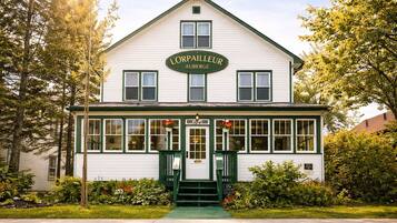 A two-story building with a sign reading 'L'Orpailleur Auberge.'
