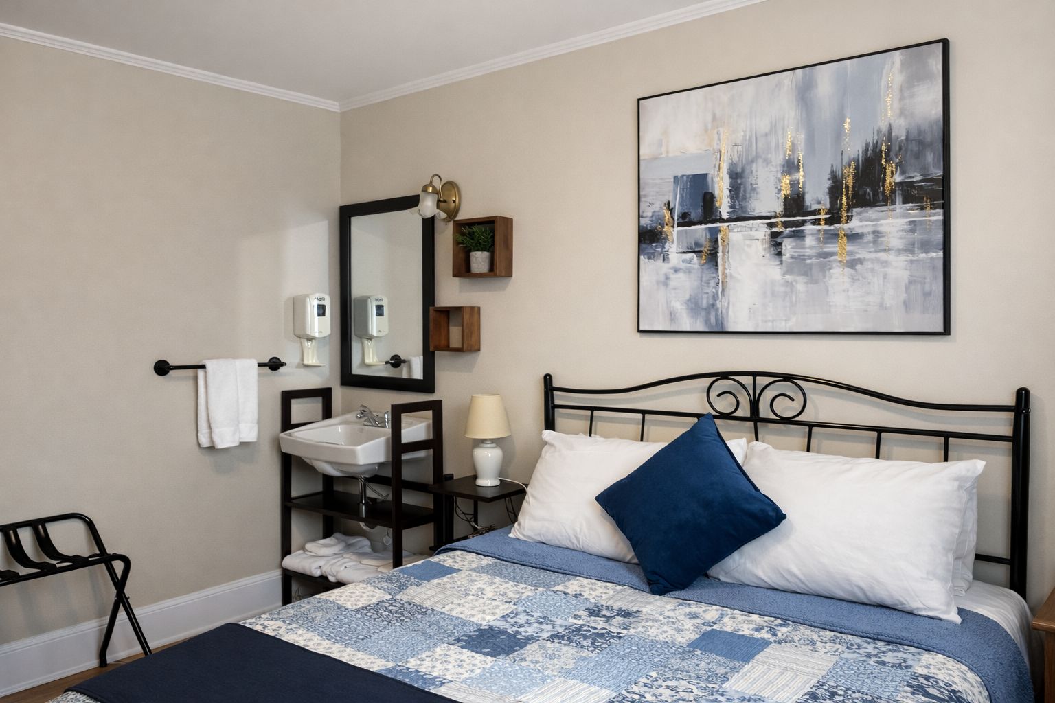 A bedroom with a bed, a nightstand, a mirror, a sink, and a wall-mounted painting.