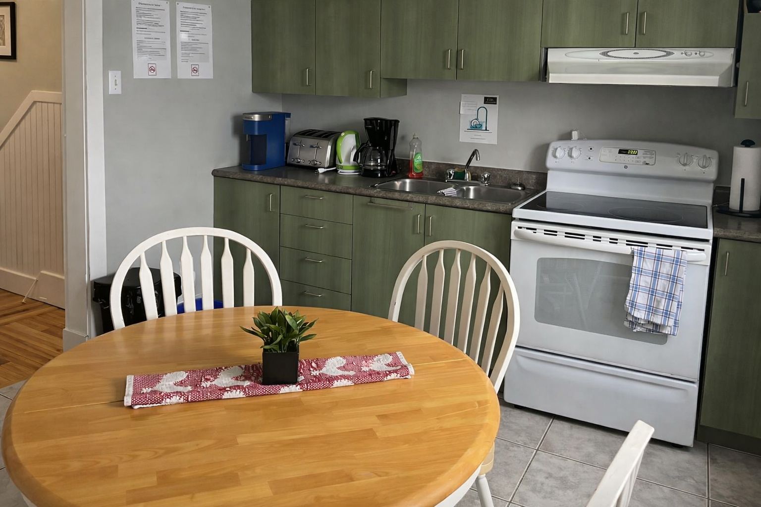 Una cucina con piano cottura, forno e un tavolo da pranzo con sedie.