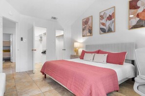 Ein Schlafzimmer mit einem Bett, einem Sessel und einem Nachttisch.