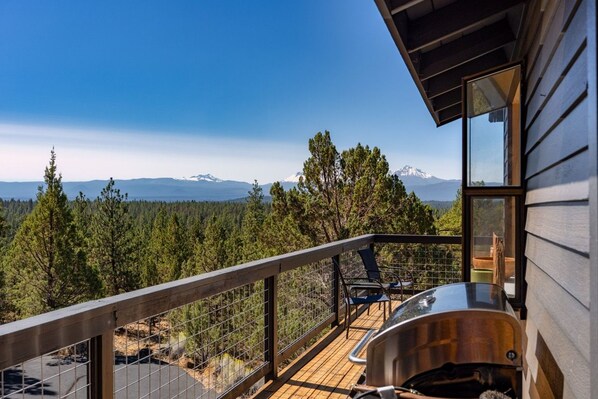 A balcony with a view of a forest and mountains.