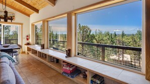 A cozy living area with a large window overlooking a mountainous landscape. - Cascade Views | Family Retreat | Dog Friendly (Sisters)
