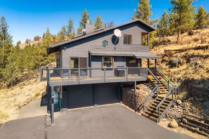 A two-story building with a balcony, a satellite dish, and a staircase leading to a garage.