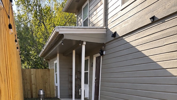 A residential property with a covered patio, a wooden fence, and a well-maintained lawn. - Downtown Bryan Apt - Walk to Everything (Bryan)