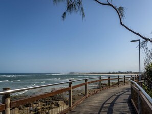 A wooden boardwalk leading to a beach with a clear sky. - Poolside 3-bed Retreat Near Kings Beach (Sunshine Coast)