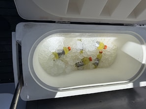 An ice chest containing bottles and ice.
