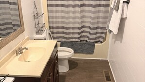 A bathroom with a sink, toilet, and shower area. - Welcome to Retreat at Delano #1 (Delano)
