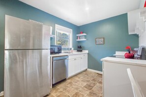 A compact kitchen with a refrigerator, microwave, and dishwasher.