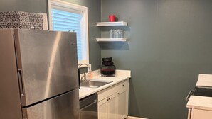 A compact kitchen with a stainless steel refrigerator, a sink, and a countertop. - Welcome to Retreat at Delano #1 (Delano)