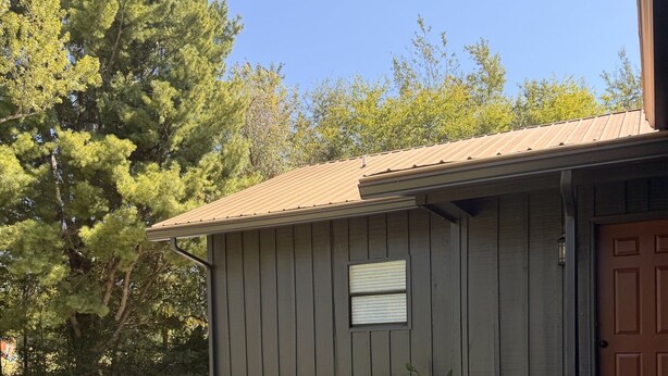 A single-story building with a brown door, a small window, and a metal roof. - Welcome to Retreat at Delano #1 (Delano)