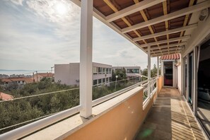 Ein Balkon mit Blick auf Gebäude und einen klaren Himmel.