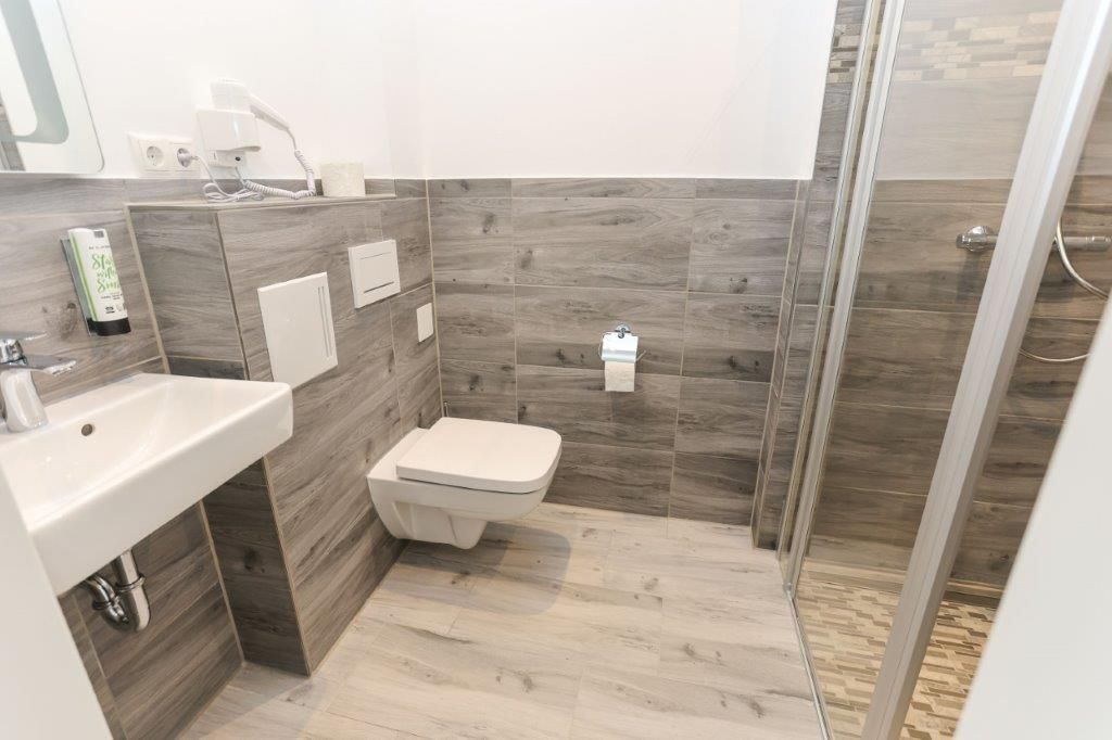 A modern bathroom with a sink, toilet, and shower area.