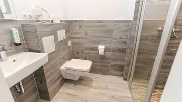 A modern bathroom with a sink, toilet, and shower area.