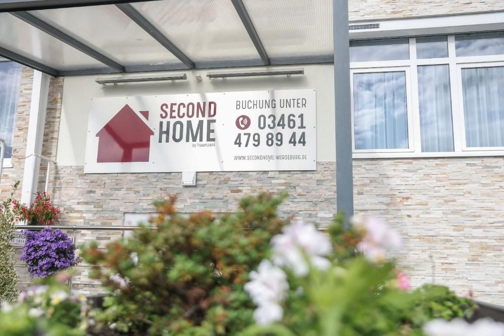 Schild für eine ‚SECOND HOME‘ Immobilie mit Kontaktinformationen und einer Website-URL.