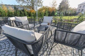 Un espace extérieur aménagé en terrasse, avec des meubles en osier et une table ronde.
