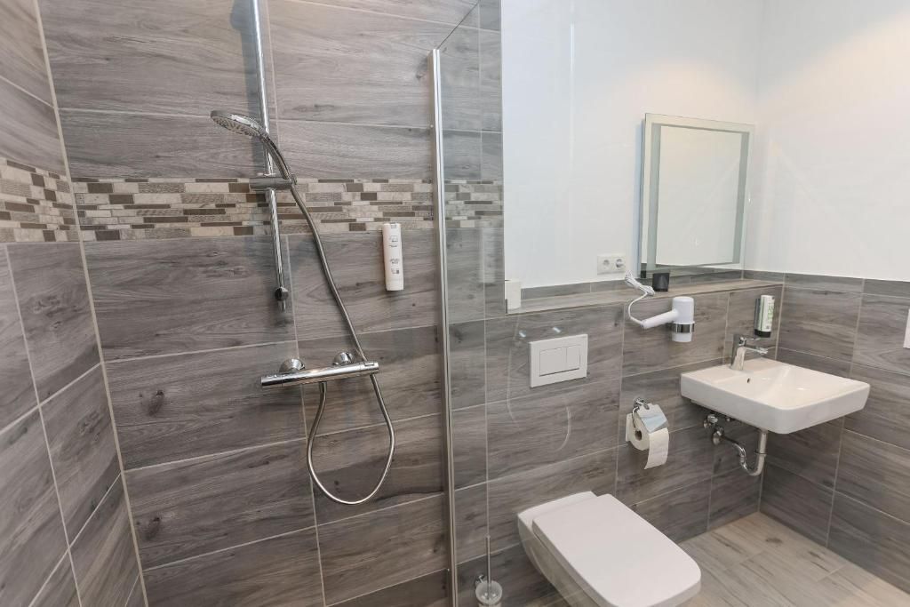 Ein modernes Badezimmer mit Dusche, Toilette und Waschbecken.
