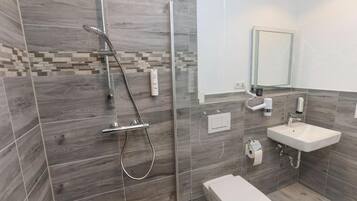 Ein modernes Badezimmer mit Dusche, Toilette und Waschbecken.