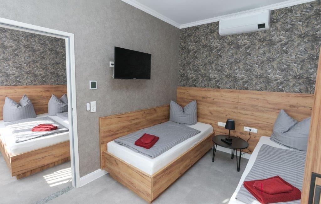 Una habitación de hotel moderna con dos camas, un televisor y una mesita.