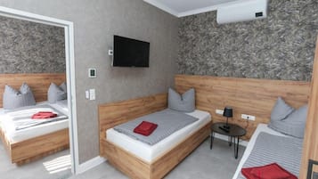 Una habitación de hotel moderna con dos camas, un televisor y una mesita.