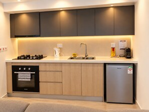 A compact kitchen with a Bosch oven, a Hisense refrigerator, and a sink with a modern faucet. - Modern 1BR SouthPark Near JKIA (Nairobi)