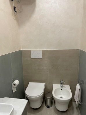 Ein modernes Badezimmer mit Toilette, Bidet und Waschbecken.