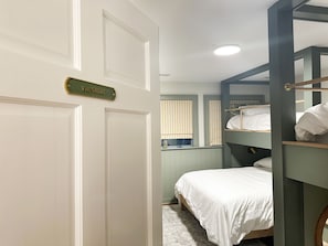 A room with bunk beds, a door with a sign, and a window with blinds. - Pen y Bryn - 5BR Blue Ridge Luxury Retreat with Pool, Library & Game Room (Faber)
