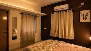 A bedroom with a bed, a ceiling fan, an air conditioning unit, and a wall-mounted picture. - 2bhk Malleswaram templeview-veg only (Bengaluru)